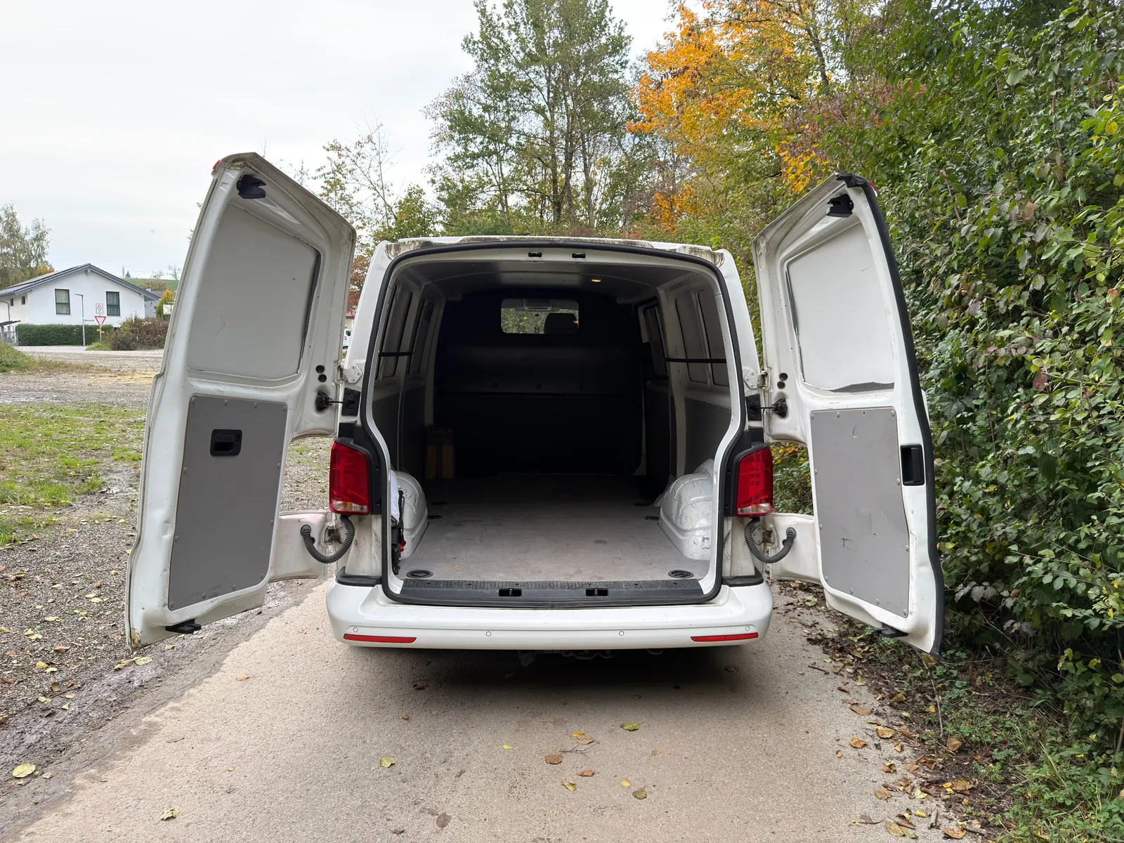 Geöffneter Laderaum eines elektrischen Kastenwagens mit Werkzeug und Transportboxen